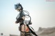 A woman in a futuristic outfit standing in the desert.