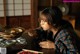 A woman sitting at a table eating a bowl of food.