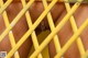 A close up of a man's penis behind a yellow fence.